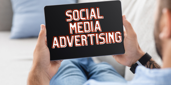 Man holding digital device with words Social Media Advertising