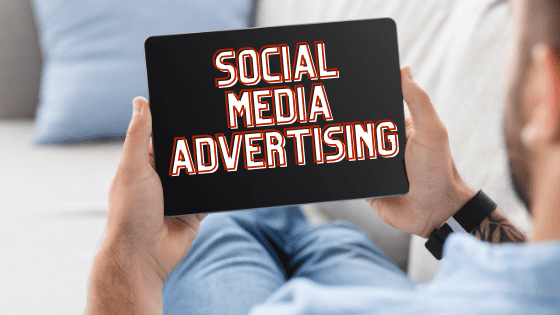 Man holding digital device with words Social Media Advertising